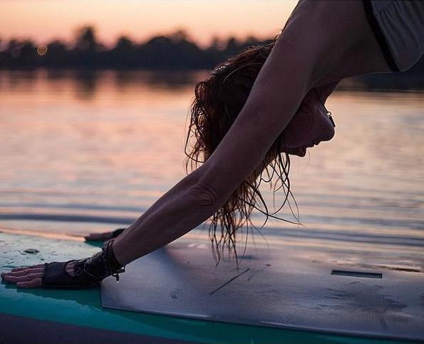 Yogi in Down Dog on Stand Up Paddle Board